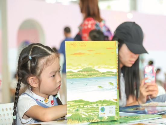 Gucken, lesen, lernen: In China, dem größten Kinderbuchmarkt der Welt, ist es völlig normal, Kinder zu großen buchrelevanten Veranstaltungen mitzunehmen. Während der Pekinger Buchmesse gibt es nicht nur auf dem Messegelände reichlich Gelegenheit, in neuen Büchern zu blättern (Foto). Auch in der Stadt werden Eltern und Nachwuchs an vielen Eventstandorten hofiert. (Foto: Beijing Book Fair)